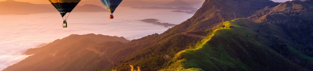 paisagem-de-nevoeiro-matinal-e-montanhas-com-baloes-de-ar-quente-ao-nascer-sol